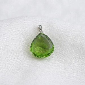 Detailed view of emerald green pear pendant bail and prong setting, artisan sterling silver jewelry