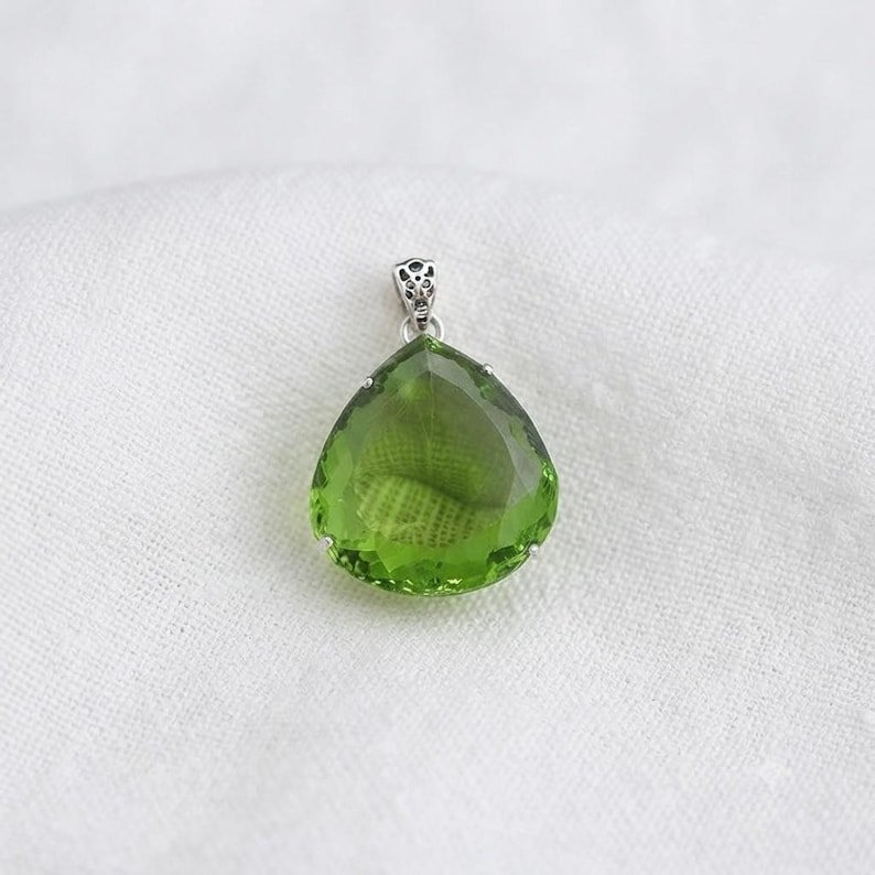 Detailed view of emerald green pear pendant bail and prong setting, artisan sterling silver jewelry
