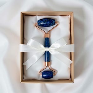 Cooling lapis lazuli facial roller on countertop, dual end crystal face massager for daily skincare