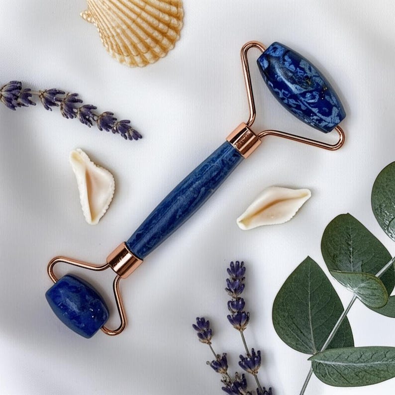 Deep blue lapis lazuli face roller with golden flecks, cooling skincare tool for puffiness look and glow