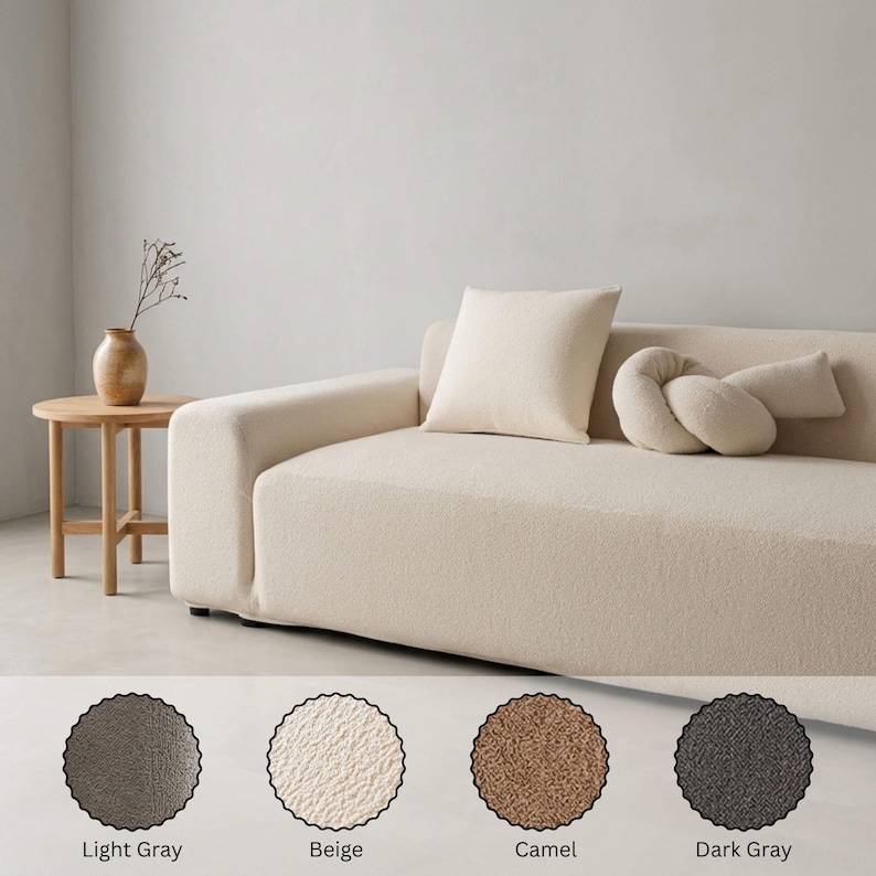 May include: A beige sofa with a square pillow and a decorative bolster. A small wooden side table with a vase is to the left. The image also shows four color swatches: light gray, beige, camel, and dark gray.
