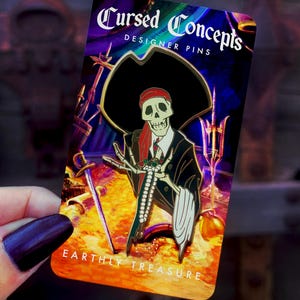 May include: A metal enamel pin featuring a skeleton wearing a black pirate hat, a red bandana, and a dark suit, holding a jeweled sword. The pin is mounted on a rectangular backing card with the text Cursed Concepts Designer Pins and Earthly Treasure.