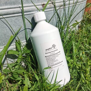 Könnte beinhalten: Eine weiße Plastikflasche mit weißem Deckel, beschriftet mit "pepSET Wurmtee Konzentrat". Die Flasche ist von grünem Gras und Blättern umgeben. Das Etikett enthält Text auf Deutsch. Es handelt sich um ein Gartenprodukt.