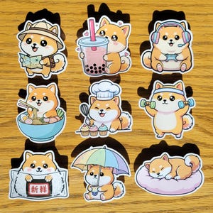May include: A collection of nine stickers featuring Shiba Inu dogs in various activities. The stickers depict the dogs with a map, bubble tea, headphones, ramen, chef hat, dumbbells, a sign with Japanese text, an umbrella, and sleeping on a pillow.