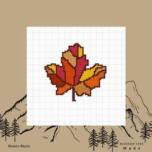 May include: A mosaic maple leaf design in shades of orange, red, and yellow, set against a grid background. The leaf is a pixelated cross-stitch pattern. The words "Mosaic Maple" and "Mountain Town Made" are at the bottom.