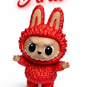 May include: A red figurine of a creature with large eyes, a toothy grin, and a furry red costume with bunny ears. The name "Aria" is written in red script above the figure.