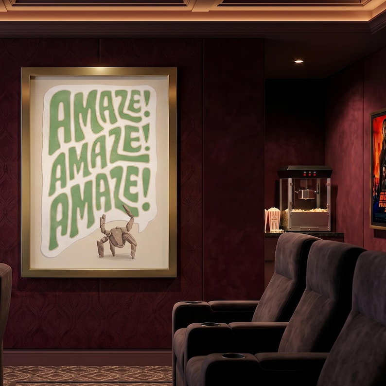 Puede incluir: Una l&aacute;mina de arte mural enmarcada con el texto AMAZE! repetido tres veces en una fuente ondulada de color verde claro. Debajo del texto, una peque&ntilde;a criatura marr&oacute;n de varias patas se encuentra sobre un fondo claro. El marco es dorado.