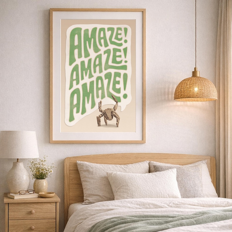 Puede incluir: Una l&aacute;mina art&iacute;stica enmarcada con fondo beige claro y un bocadillo blanco ondulado que contiene el texto verde "AMAZE! AMAZE! AMAZE!" apilado verticalmente. Debajo del texto hay una peque&ntilde;a ilustraci&oacute;n detallada de un cangrejo marr&oacute;n.