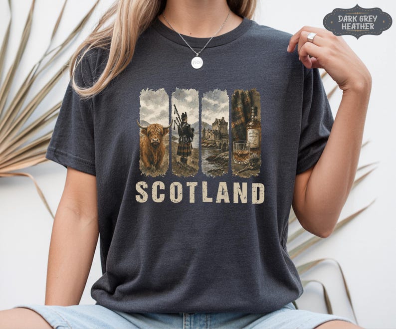 May include: Dark grey heather t-shirt with a Scotland graphic. The graphic features a Highland cow, a bagpiper, a castle, and a bottle of whiskey with a glass. The word "SCOTLAND" is printed in a distressed font below the images.
