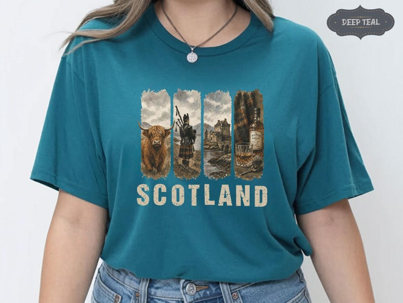 May include: Teal t-shirt featuring a graphic design with Scottish imagery. The design includes a Highland cow, a bagpiper, a castle, and a glass of whiskey. The word "SCOTLAND" is printed in a distressed font below the images.