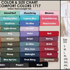May include: Color and size chart for Comfort Colors 1717 unisex heavyweight tees. The chart displays a variety of colors, including white, black, and red. Size measurements are provided in inches, with a white tee on a hanger.