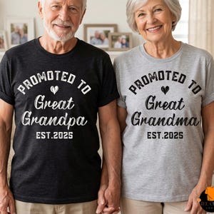May include: Two people wearing matching t-shirts. One shirt is dark gray and the other is light gray. Both shirts have the text "Promoted to Great Grandpa" and "Promoted to Great Grandma" with "EST. 2025".