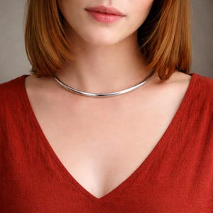 May include: A white ceramic mug with a black handle and the text "But First, Coffee" in a bold, black font. The mug is set against a neutral background, highlighting its simple design.