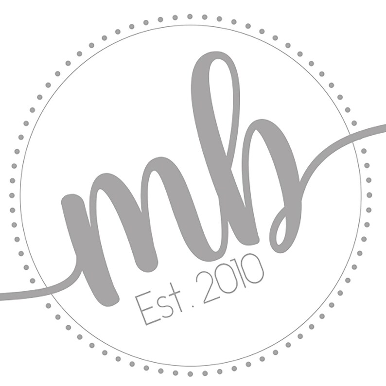 Może przedstawiać: Szare koło z kropkowanym obramowaniem i tekstem "mb" w ozdobnym, pochylonym piśmie. Pod tekstem znajduje się napis "Est. 2010".