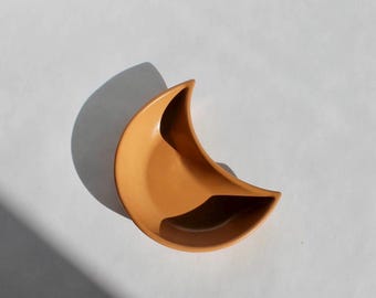 Plato pequeño de hormigón con forma de luna en arcilla