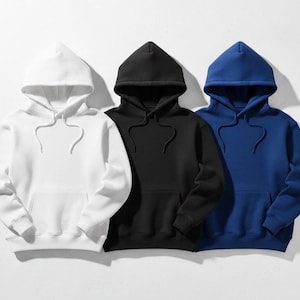 Op de afbeelding: Drie hoodies in wit, zwart en blauw. Elke hoodie heeft een capuchon met trekkoord en een kangoeroezak aan de voorkant. De hoodies zijn gemaakt van een zacht, comfortabel materiaal.