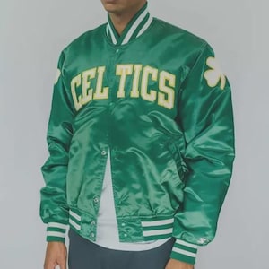 May include: Green satin jacket with the word "CELTICS" in yellow block letters across the chest. The jacket has white and green striped cuffs and collar. A shamrock is on the right side of the jacket.