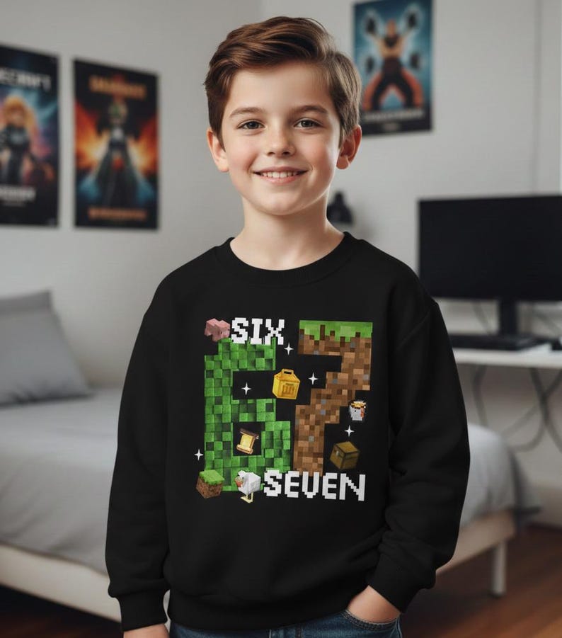 May include: A black sweatshirt featuring a pixelated design with the words "SIX SEVEN" and Minecraft-themed graphics. The design includes blocks, a pig, and other game elements. The sweatshirt is worn by a smiling child.