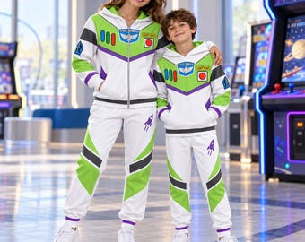 Puede incluir: Un conjunto de sudadera con capucha y cremallera y pantalones de chándal en blanco, verde y morado con gráficos de Buzz Lightyear Space Ranger, que incluye un emblema en el pecho, botones de panel de control y un icono de cohete.