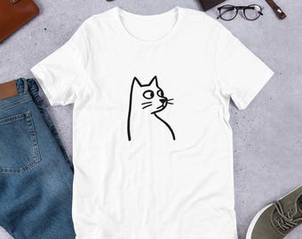 Könnte beinhalten: Weißes T-Shirt mit einer minimalistischen schwarzen Katzenillustration. Die Katze ist mit einfachen Linien gezeichnet, die ihren Kopf und einen Teil ihres Körpers zeigen. Das T-Shirt besteht aus einem weichen Material und eignet sich für den lässigen Gebrauch.