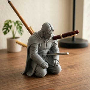 Könnte beinhalten: Eine weiße Keramik-Tasse mit schwarzem Henkel und dem Text "But First, Coffee" in schwarzer, handschriftlicher Schrift. Die Tasse steht auf einer weißen Oberfläche.