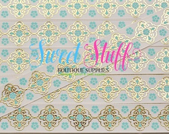May include: White ribbon with a gold and teal patterned design. The pattern features a repeating geometric design with a gold outline and teal fill. The ribbon is 1.5 inches wide and is perfect for crafting and decorating.