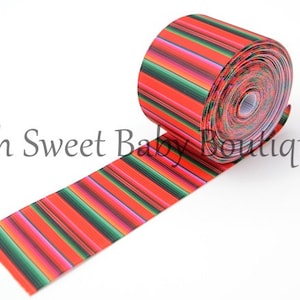 May include: Red, green, and pink striped ribbon with a Mexican-inspired pattern. The ribbon is rolled up and ready to be used for crafting or decorating.