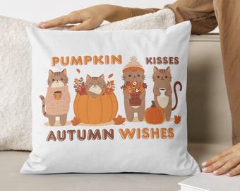 May include: White square pillow with a fall-themed design. The pillow features four cartoon cats with autumn elements, including a pumpkin, leaves, and coffee cups. The text "PUMPKIN KISSES AUTUMN WISHES" is printed in orange.