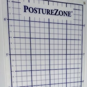 May include: A clear, rectangular posture assessment tool with blue grid lines and measurement markings. The text "POSTUREZONE" is at the top, with a website address at the bottom. The tool is mounted on a gray wall.