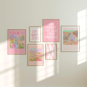 May include: A collection of framed art prints in soft pink and beige tones. The prints feature inspirational quotes and landscape illustrations. Text includes "Psalm 27", "Love Like Jesus", "His Mercies Are New Every Morning", "Proverbs 31", "Psalm 23", and "Amen".