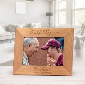 May include: A light brown wooden picture frame with the words "Faithful Servant" and "Hebrews 6:10" engraved at the top. The frame also includes the text "Ben Harris 25 YEARS OF SERVICE" at the bottom. The frame holds a photo of two men.