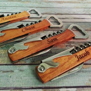 May include: Four wooden bottle openers with corkscrews and personalized names: Austin, Chase, Sam, and Jacob. Each opener has a silver bottle opener and corkscrew.