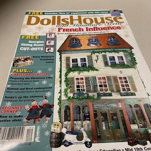 Könnte beinhalten: Ein Magazin-Cover für Dolls House and Miniature Scene mit einem französischen Puppenhaus mit einer Weinshop-Fassade. Das Cover enthält auch eine Ausschneidevorlage für ein georgianisches Esszimmer, einen Weihnachtskuchen und einen festlichen Kranz.