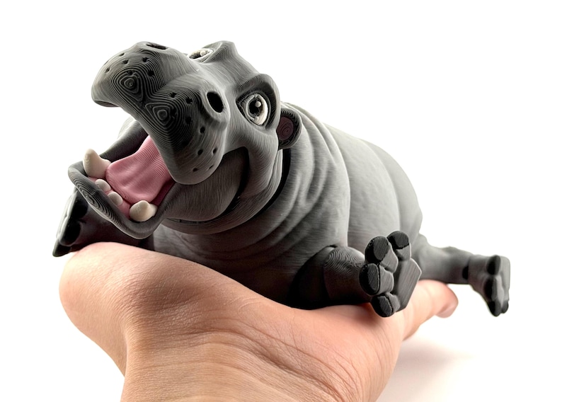 K&ouml;nnte beinhalten: Eine wei&szlig;e Keramik-Tasse mit schwarzem Henkel und dem Text "But First, Coffee" in fetter, schwarzer Schrift. Die Tasse steht vor einem neutralen Hintergrund, der ihr schlichtes Design hervorhebt.