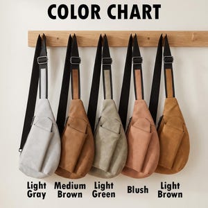 May include: A color chart of five sling bags in various shades: light gray, medium brown, light green, blush, and light brown. Each bag has a black strap and a front pocket. The bags are hanging on a wooden rack against a white wall. The text "COLOR CHART" is at the top.