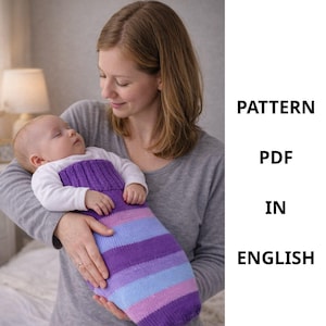 May include: A sleeping baby wrapped in a purple, blue, and lavender striped knitted cocoon. The cocoon is held by a person wearing a gray long-sleeve shirt. The text on the right side of the image reads: PATTERN, PDF, IN, ENGLISH.