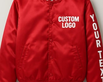 May include: A red satin bomber jacket with white striped cuffs and collar. The jacket features the text "CUSTOM LOGO" on the chest and "YOUR TEXT" on the sleeve in white.