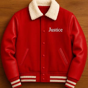 Pode incluir: Casaco universitário vermelho com gola de sherpa branca e punhos listrados brancos. A palavra "Justice" é impressa em branco no peito. O casaco tem fecho de botões e dois bolsos frontais.