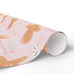 Rolled sheet of personalized Christmas gift wrap with gingerbread girls and festive treats