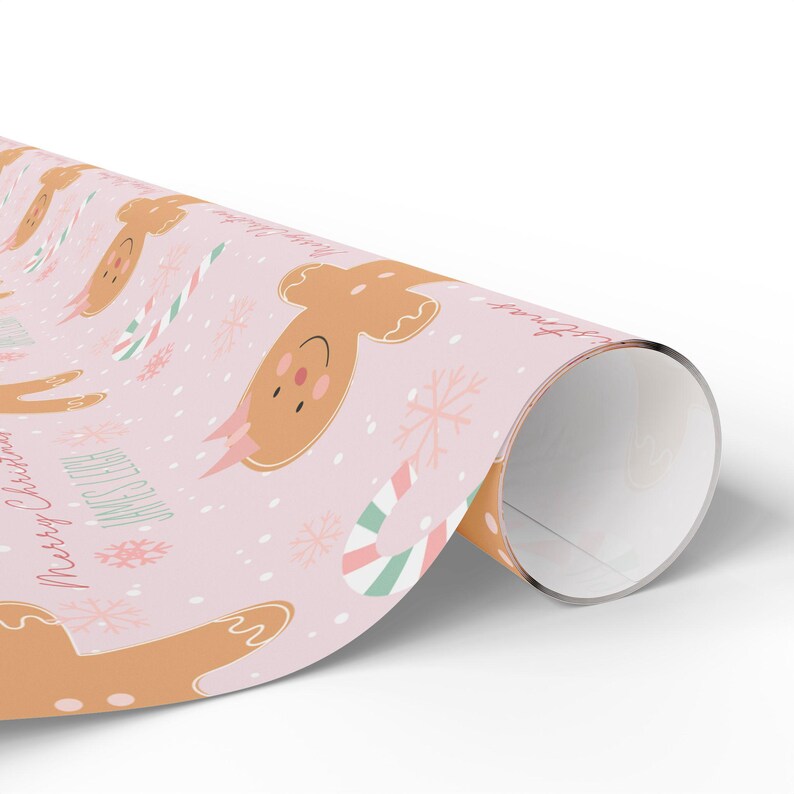 Rolled sheet of personalized Christmas gift wrap with gingerbread girls and festive treats