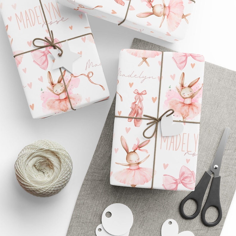 Flat lay of pink ballet bunny gift wrap with personalized name, ideal for custom girls birthday packaging.