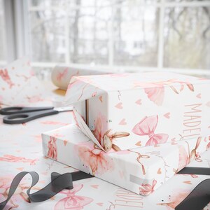 Custom birthday wrapping paper featuring ballerina bunnies and hearts being wrapped around gifts.