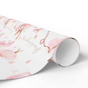 Rolled girls birthday gift wrap with pink ballerina bunny and personalized name design.
