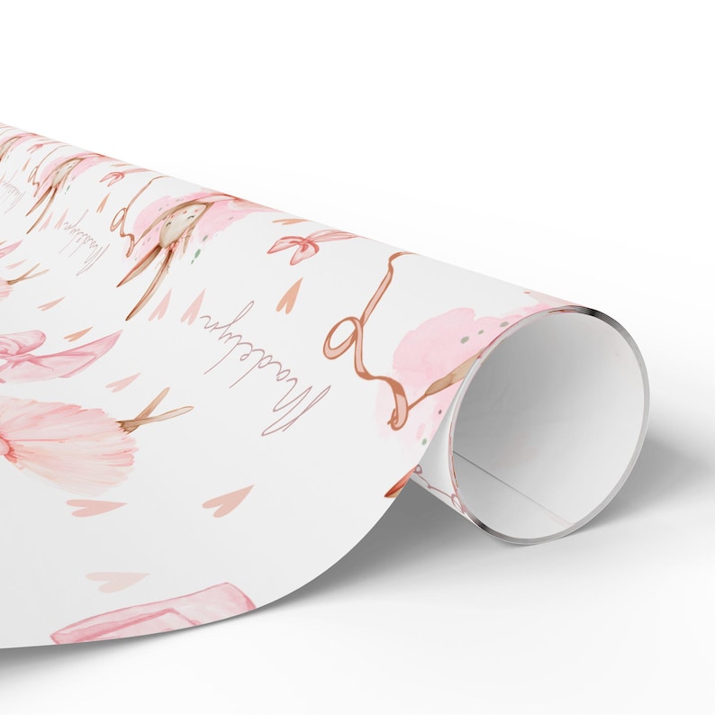 Rolled girls birthday gift wrap with pink ballerina bunny and personalized name design.