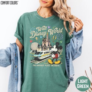 A woman wearing a green t-shirt with a Disney World graphic and text, including Mickey Mouse and the Walt Disney World logo.
