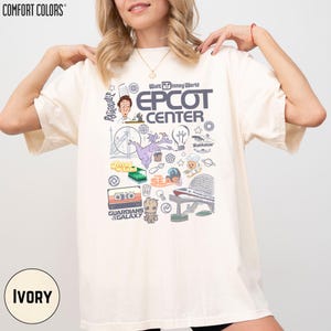 A woman wearing a white t-shirt with various Disney-themed graphics and text, including the words "EPCOT CENTER" and "Disney World".