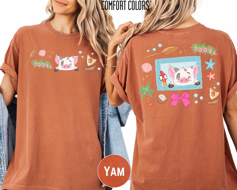 a woman wearing a brown t-shirt with a cartoon pig design and various colorful elements, such as flowers, stars, and a bow.