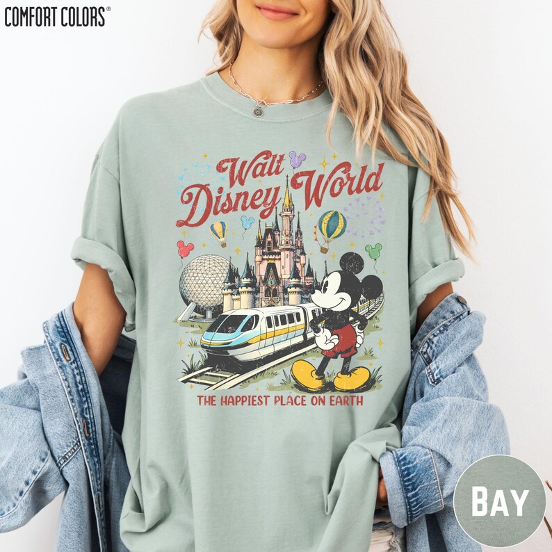 A woman wearing a t-shirt with a Disney World graphic and text, including Mickey Mouse and a roller coaster.