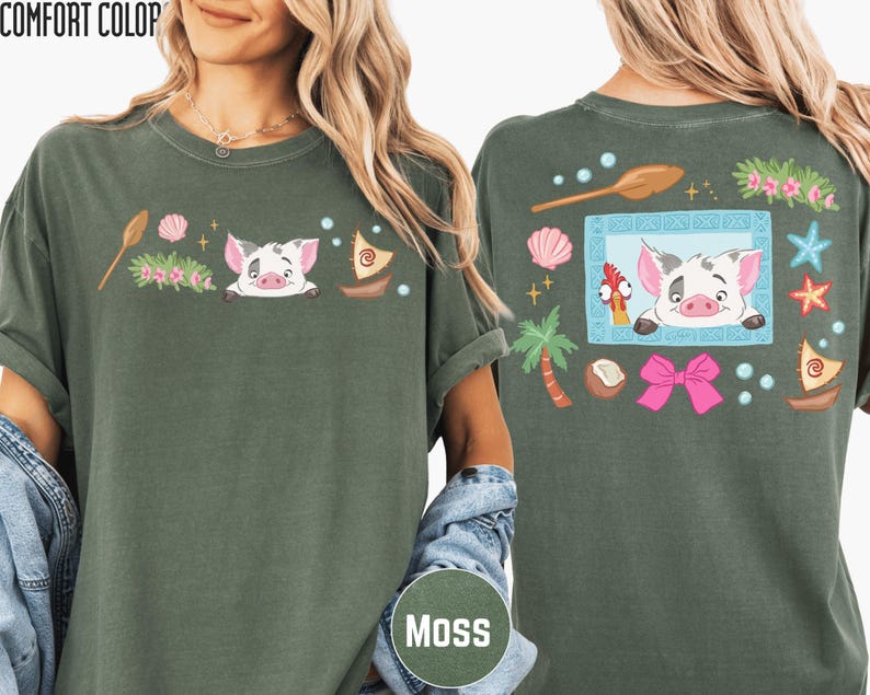 A woman wearing a green t-shirt with a cartoon pig and various other colorful elements on the front and back.