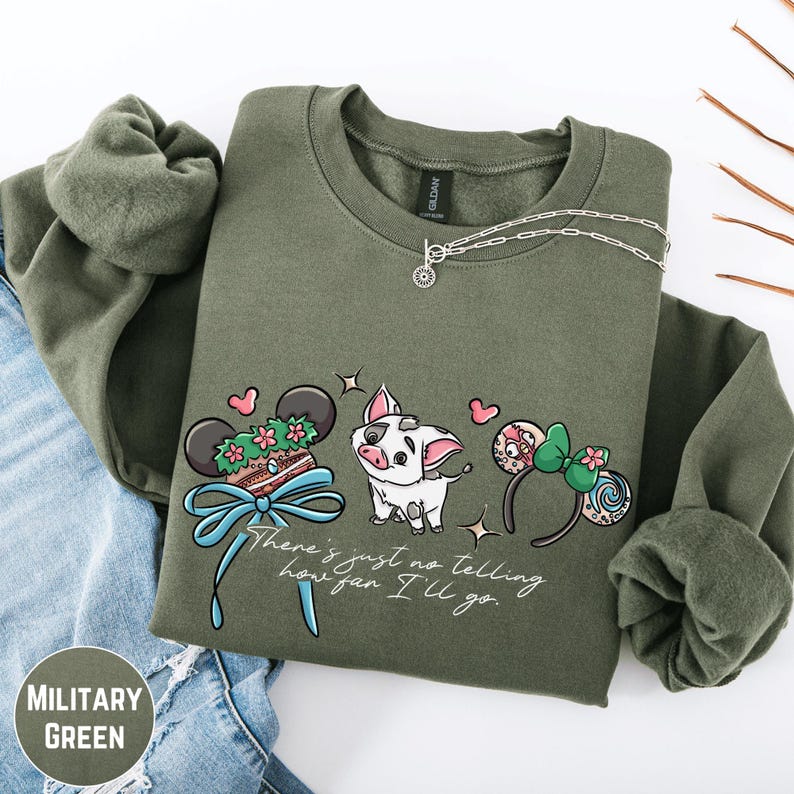 A military green sweatshirt with a graphic design featuring a pig, a pair of ears, and a bow, along with the text "There's just no telling how far I'll go".